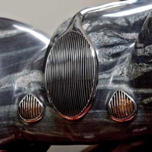 “Drive” is a quartzite Jaguar with stainless steel trim that cruises on a Brazillian cherry highway atop a steel base, by Andreas von Huene of Arrowsic. Courtesy of Dennis Griggs Andreas von Huene