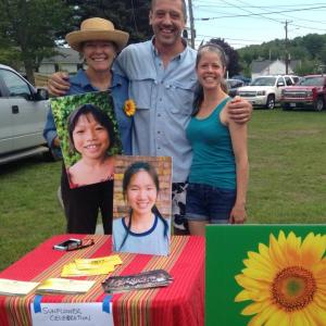 Crystal and Seth Lewis of Blue Tin Farm join Friends of Thai Daughters co-founder, Patty Zinkowski at the Boothbay Farmers Market. Tickets for FTD’s Sunflower Celebration event are for sale at the Blue Tin Farm stand. Courtesy photo