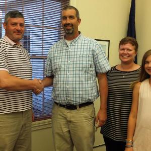 Boothbay Town Manager Dan Bryer, left, congratulates new Code Enforcement Officer Jason Lorrain, as Lorrain’s wife Heather and daughter Emery are introduced during the Aug. 23 selectmen’s meeting. BILL PEARSON/Boothbay Register
