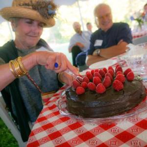 Luana Frois of Westport Island slices into a chocolate whiskey cake for which she and her husband were high bidders at Lincoln County Historical Association’s Kermess at Pownalborough Court House. Courtesy of Sarah Sutter