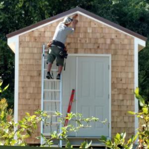 Peter Hallett nails final shingle in place on Diaper Bank's new storage house. Courtesy photo