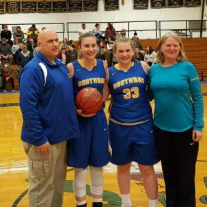 Page Brown, with the ball, stands with her parents, Ted and Lauren Brown, and her sister, Kylie, after she scored her 1000th career point at Mt. Abram Thursday night, Dec. 14. Courtesy of Allan Crocker