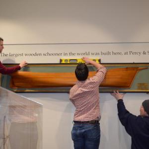 From left, museum staff members Kelly Page, Chris Timm and Dayne Dennett install the heavy half-model of Wyoming into the Johnny and Lorraine Ring Wyoming Gallery at MMM. Courtesy of MMM