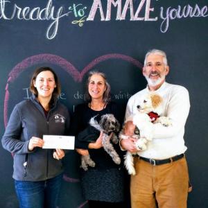 Kate Griffith of the Lincoln County Animal Shelter, left, receives a check from Crow Point Yoga instructor Wendy Johnson with studio mascot The General, Doug Goldhirsch (one of the studio owners) with Olaf. Funds were raised through Crow Point Yoga’s Karma Yoga classes. Courtesy of Ashlea Tibbetts