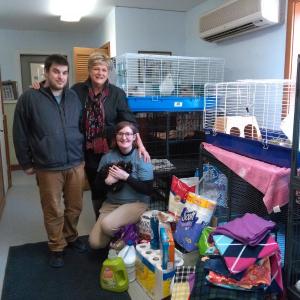 Kurtis Reed, left, Community Center Director Jane Good, center, and Veronic Ngai, kneeling, unload items donated by Community Center volunteers to the Lincoln County Animal Shelter. JANE CARPENTER/Boothbay Register