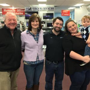 Russell Brackett, left, Leisha McDonald, and Nick, Emily and the star of the show, Oscar Mirabile, at Harbor-Tech Solutions in Boothbay Harbor. SUZI THAYER/Boothbay Register