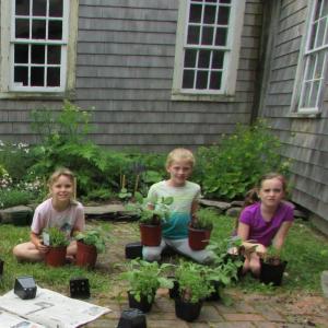 Addie Miller, Piper McKane and Flannery Brady pot herbs in front of the Chapman-Hall herb garden. The historic house will be open for Mother’s Day for tours and a plant sale. Courtesy photo