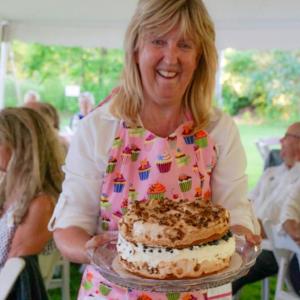 LCHA volunteer Terri Wells displays a cake during the auction of desserts at last year’s Kermess. Courtesy of Sarah Sutter