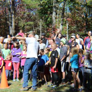 A volunteer explains the obstacle course to a large group of kids at last year’s Race Through the Woods event. Courtesy of Midcoast Conservancy