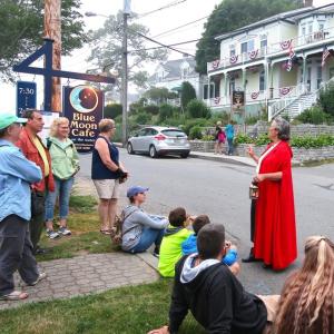The Lady in the Red Cloak sharing a chilling tale in Boothbay Harbor. Courtesy of The Lady