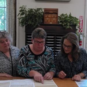 Register of Probate Catherine Moore, center, reviews passport information with Deputy Register Jeannine Clark, right, and Clerk Lisa LaPlante, left. JANE CARPENTER/Boothbay Register