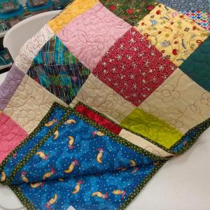 A stack of quilts destined for the Rotary’s wrap a smile program waits at the Community Center. JANE CARPENTER/Boothbay Register