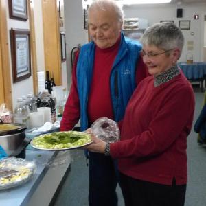 Health Center board member Carl Hamrin and Jane Homer admire a dish at Boothbay Region Health Center’s healthy potluck dinner. JANE CARPENTER/ Boothbay Register