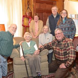 Jean Thompson holds Southport’s Boston Post Cane, presented to her by the town’s selectmen (all kneeling, from left), Smith Climo, Mary Lou Koskela (Jean’s daughter) and Gerry Gamage. Looking on are Jean’s other daughter, Anne Maher, son-in-law Phil Koskela and granddaughter, Carrie Koskela. Robert Mitchell photo