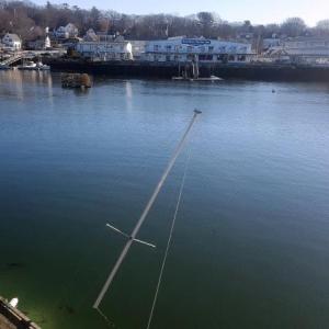 The mast is the only thing seen of this sailboat, pinned underneath the dock against pilings at Mystic Mermaid. STEVE EDWARDS/Boothbay Register