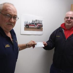 Rotarian Daren Graves, left, hands Edgecomb Fire Chief Roy Potter a check for $1,000 from the Rotary’s Hometown Heroes Fund. The money will be used to buy a digital radio for the town’s new fire truck. JANE CARPENTER/Boothbay Register