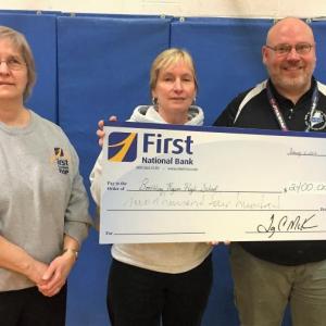 First National Bank’s Cathy Latter, left, and Shelley Smith presenting the First Hoop check to Boothbay Region High School’s Athletic Director Allan Crocker. Courtesy of First National Bank