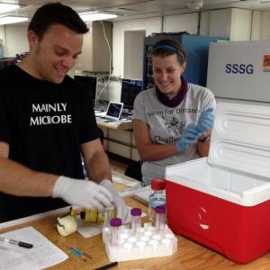 Study author Stephanie Carr works with a student to process deep-sea samples aboard the R/V Atlantis. A recent study found that
a group of unusual microbes living below the seafloor provides clues to the evolution of life on Earth, and potentially other planets. Courtesy of Beth Orcutt/Bigelow Laboratory for Ocean Sciences