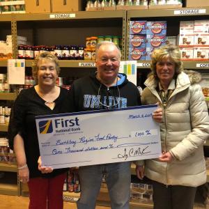 First National Bank’s Branch Manager Brenda Blackman, right, and Assistant Branch Manager Christina Stevens present a check to Tom Wilson of the Boothbay Region Food Pantry. Courtesy photo