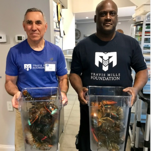 Robinson’s Wharf chef Andre Finley, right, helps an unidentified Travis Mills Foundation volunteer carry some lobsters, donated by the Southport restaurant, to the Foundation. Sarah Sherman photo