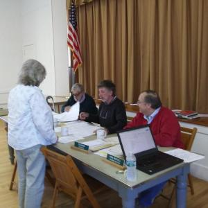 Town Clerk Claudia Coffin presents the town warrant to Edgecomb selectmen for their approval. JANE CARPENTER/Boothbay Register