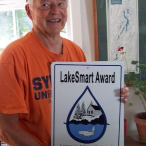 Homeowners receive recognition for meeting LakeSmart standards. Peter Crooker of Pemaquid Pond shows off his LakeSmart award. Courtesy photo