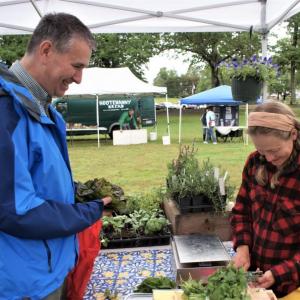 Lincoln Medical Partners physician Timothy Goltz, MD, left, purchases some fresh produce from Brady Hatch of Morning Dew Farm at the Damariscotta Farmer’s Market. Courtesy of LincolnHealth