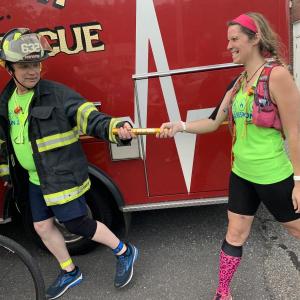 In Wiscasset Aug. 11, Woolwich’s Danny Evarts takes the Run 2 Respond baton from Portland’s Tanya Holbrook. SUSAN JOHNS/Wiscasset Newspaper