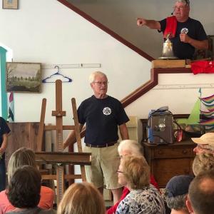 Peter Kidder displays a vintage art easel as Fire Chief Gerry Gamage keeps track of the bids. Courtesy of Amy Hilstrom