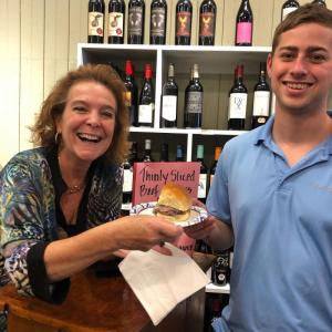 Stacy McLellan, owner of Caper’s Deli, offers a slider to a returning Harbor Fest customer who recently served military time in Afghanistan. Lori Reynolds photo