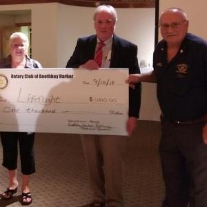 Event co-chairs Debbie and Daren Graves present a $1,000 check for LifeFlight to Executive Director Tom Judge, center. JANE CARPENTER/Boothbay Register