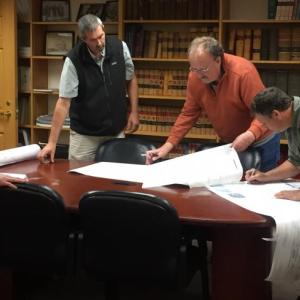 Bill Cloutier of West Newbury, Massachusetts watches as Boothbay Code Enforcement Officer Jason Lorrain, second from left, helps planning board members Bruce Bowler and Rob Ham, right, to sign the mylar plan for registering changes to his Barters Island summer home renovations. BILL PEARSON/Boothbay Register