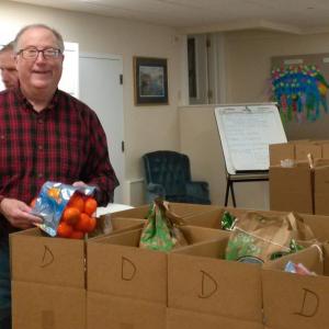 Boothbay Region Food Pantry co-president Fleet Davies helps fill the Thanksgiving boxes in 2018. File photo