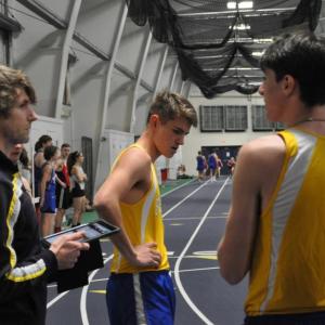 Coach Nick Scott speaks with Fox Elder, center, and Will Perkins at a meet last year. Courtesy of Kerrin Erhard