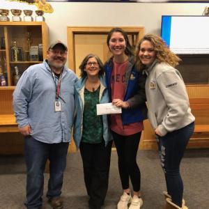Glory Blethen hands a $650 check to Mary Hanley of New Hope for Women representing the money raised during the recent “wear purple” day. At left is BRHS athletic director Allan Crocker and at right is fellow BRHS girls basketball player Jaelyn Crocker. Courtesy photo