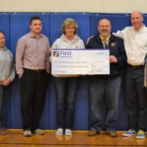 Boothbay Harbor branch manager Brenda Blackman and Boothbay Region High School athletic director Allan Crocker hold a mock check for $2,300, the First Hoop donation to BRHS from the First National Bank. Pictured from left are First National Bank employees Evelin Carrasco and Jolleen Marshall, BRHS boys basketball junior varsity coach Dan Hallinan, Blackman, Crocker, BRHS girls basketball varsity coach Brian Blethen and Susan Norton, executive vice president/chief administrative officer of First National Bank. KEVIN BURNHAM/Boothbay Register
