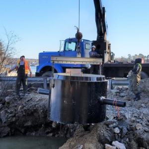 One of the many steps in replacing the West Harbor Pond siphon. On December 13, 2018, a crane lowers a manhole cylinder into place. Merritt Blakeslee photo