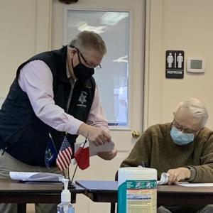 Sheriff Todd Brackett seeks Lincoln County Commissioner Bill Blodgett’s signature for renewing four shellfish contracts Jan. 26 during the bimonthly meeting. BILL PEARSON/Boothbay Register