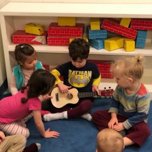 Logan Cherry plays the uke with friends looking on. Courtesy of Emily Sue Barker