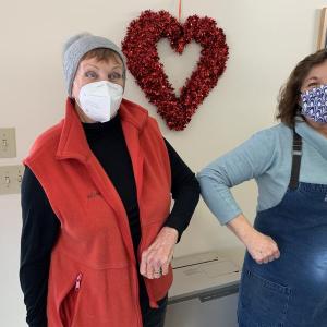 Southport Island Association President Alice Neily Mutch, left, and Southport General Store manager Nancy Long touch elbows Feb. 8 celebrating the “Love and Lasagna” fundraiser which will provide 60 free dinners to islanders on Valentine’s Day. BILL PEARSON/Boothbay Register