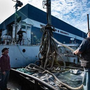 Tugboat crew member Mark Stover brings a tow line onto the tugboat. Jim Fossett photo