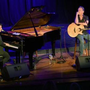 Ellis Paul and his guitar. Guinness in concert in 2019 at the Opera House. The show also featured Seth Glier (at piano) and Abbie Gardner. Who will appear with him this time? Peter Southwick photo Ellis Paul and Seth Glier