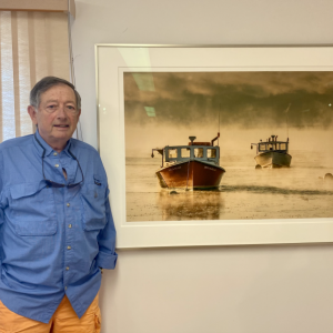 Ed Kenney stands next to the cover photo for his new book “The Winter Coast of Maine.” ISABELLE CURTIS/Boothbay Register