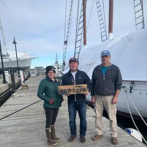 Mark Gimbel, center, presents an original plank from the Schooner Bowdoin to Sara Miller, left, chief mate on Bowdoin, and Captain Dana Willis, marine operations manager. Dianne Gimbel photo