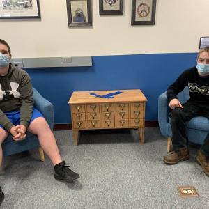Boothbay Region High School students Bret Smith, left, and Nicholas Giles turned an old library card catalog into a new end table for the school library. Courtesy photo