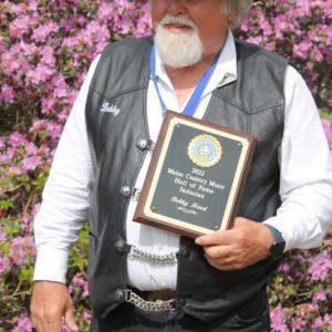 Bobby Reed holds the Maine Country Music Hall of Fame plaque he received May 15. Courtesy of Brittany Reed
