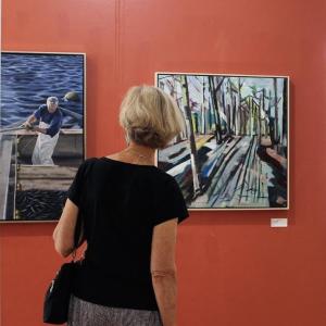 A visitor to the recent opening of Surroundings at the Maine Art Gallery views two distinctive, but complementary works of art. Photo by Elizabeth Campbell