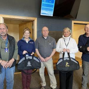 School Resource Officer Larry Brown, right, presents “go-bags” to, from left, Steve Lorrain, Shawna Kurr, David Benner and Tricia Campbell. Courtesy photo
