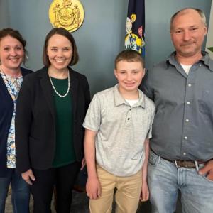 Colby Doucette, a Boothbay Region Elementary School seventh grader, with Secretary of State Shenna Bellows and his parents, Jessica and Michael Doucette, at the essay contest awards ceremony. Courtesy of the Office of the Secretary of State
