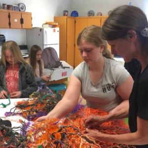Pamela Moulton helps Addie Barter unravel reclaimed fishing rope for the BRES art project. In the background, from left, Brianna Campbell and Gabrielle Cassidy work on their own ropes. FRITZ FREUDENBERGER/Boothbay Register